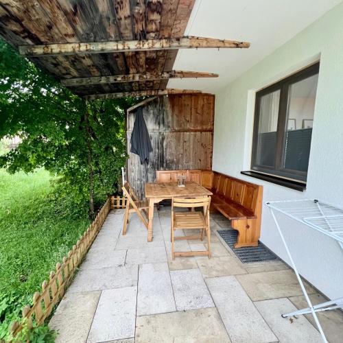 a patio with a wooden table and chairs at Ferienwohnung Landurlaub in Bad Feilnbach