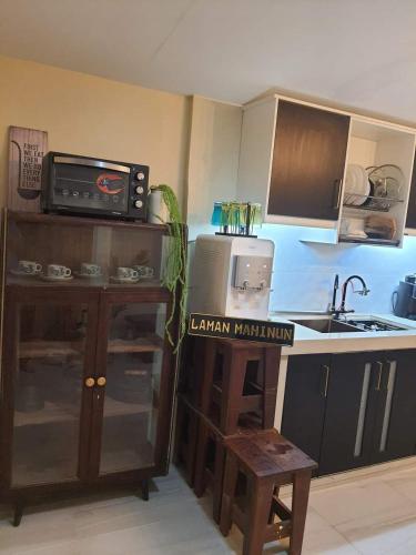 a kitchen with a sink and a counter with a microwave at Laman mahinun homestay in Pekan