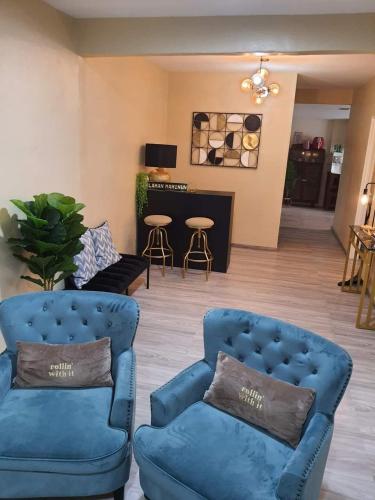 a living room with two blue chairs and a table at Laman mahinun homestay in Pekan