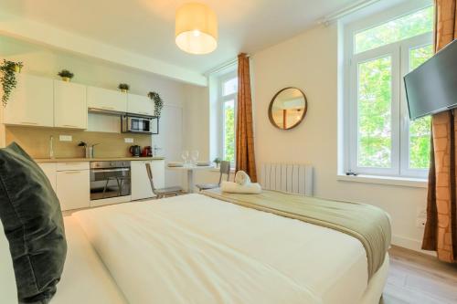 une chambre avec un grand lit et une cuisine dans l'établissement Lille Sébastopol nice studio, à Lille