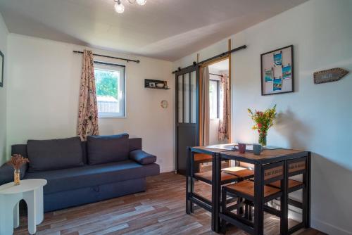 un salon avec un canapé et une table dans l'établissement La Cabane des Embruns - 3min de la Plage, à Sarzeau