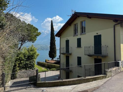 a house with a fence in front of a lake at Residence Matilde in Oliveto Lario