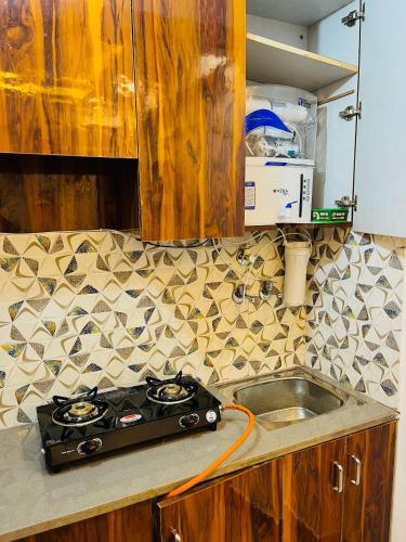 a kitchen counter with a stove and a sink at Luxury 1 RK in New Delhi in New Delhi
