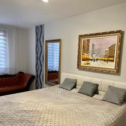 a bedroom with a bed and a painting on the wall at Zajer Apartment Ház in Hajdúszoboszló