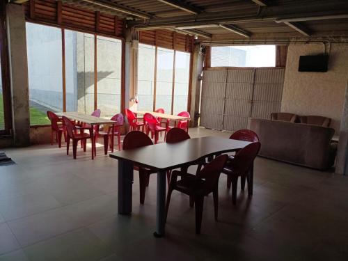 a group of tables and chairs in a room with windows at Casa Manolo Camiño Do Santiaguiño in Vedra