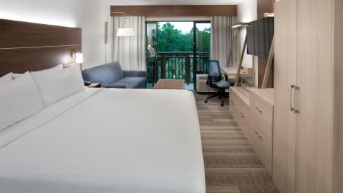 a hotel room with a bed and a living room at Holiday Inn Express Hilton Head Island by IHG in Hilton Head Island