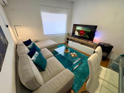 a living room with a couch and a flat screen tv at Aer Rural Apartment - Casillas Valle de Ayora in Jalance