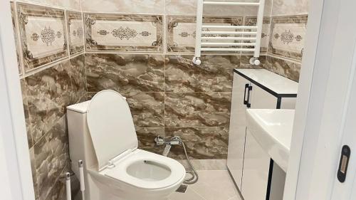 Un baño pequeño con inodoro y lavabo. en Top floor Aleksidze Apt with Terrace & views, en Tiflis
