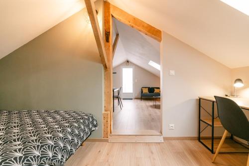 - une chambre mansardée avec un lit et un bureau dans l'établissement Chez Jo' parking et jardin, calme et cosy WisdhomeConciergerie, à Rodez