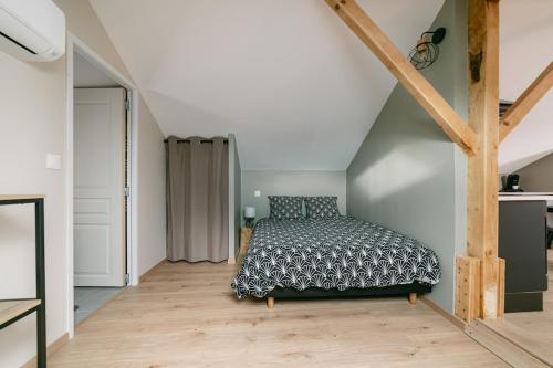 une chambre avec un lit dans un grenier dans l'établissement Chez Jo' parking et jardin, calme et cosy WisdhomeConciergerie, à Rodez
