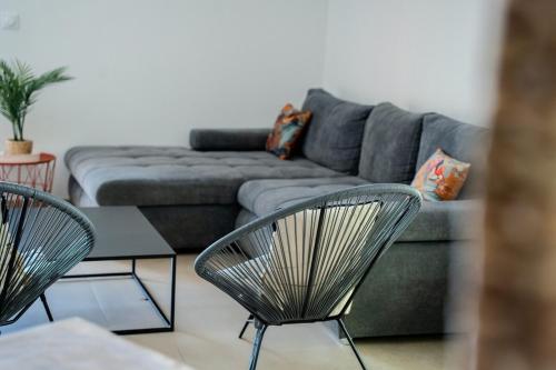 a living room with two chairs and a couch at Lou Tavan - Villa Rénovée avec Piscine & Jacuzzi - 4 Chambres in Le Lavandou