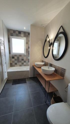 une salle de bain avec deux lavabos et un miroir dans l'établissement Villa Adishatz, new house, pool & garden, à Hourtin