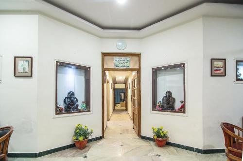 a hallway with white walls and two windows at Hotel O Lukergunj Holidays in Muthiganj