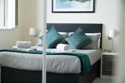 a bedroom with a large bed with blue pillows at Bromley Station in Bromley