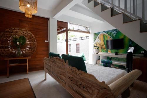 a bedroom with a bed in a room with a staircase at Marni alas villa ubud in Tegalalang