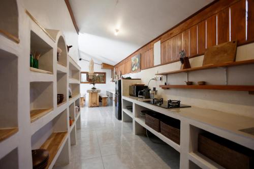 a kitchen with wooden cabinets and a long hallway at Marni alas villa ubud in Tegalalang