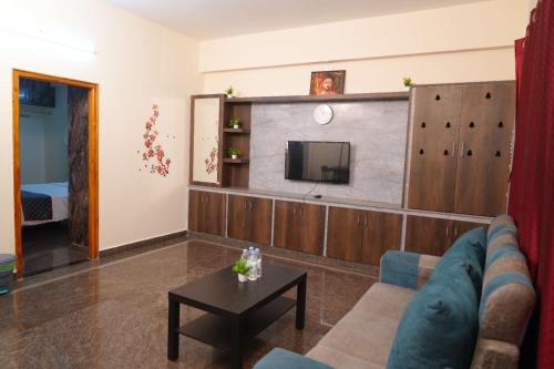 a living room with a couch and a tv at Sanskriti Homestay in Tirupati
