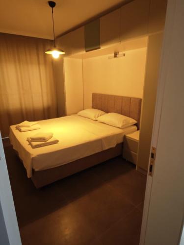 a small bedroom with a bed with white sheets at Dentist Bulent's Villas in Kusadası