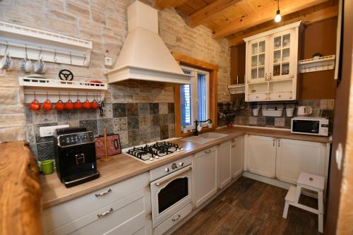 a kitchen with white cabinets and a stove top oven at Palomino house in Sinj