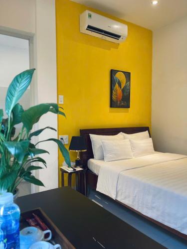a bedroom with two beds and a table with a plant at KHÁCH SẠN ROMO in Quang Ngai