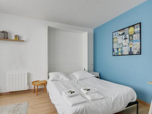 a bedroom with a white bed with two towels on it at Quiet studio between train stations and the Opera. in Lille