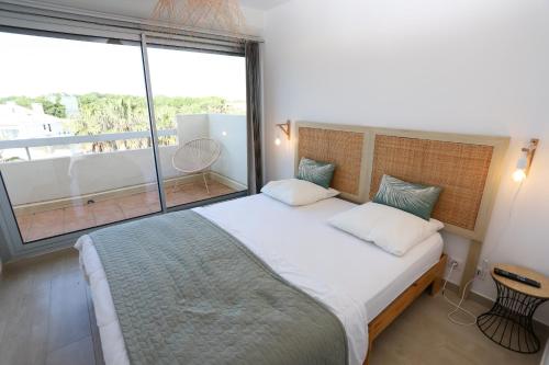 une chambre avec un grand lit et une grande fenêtre dans l'établissement Duplex face mer avec solarium et piscine, à Saint-Cyprien