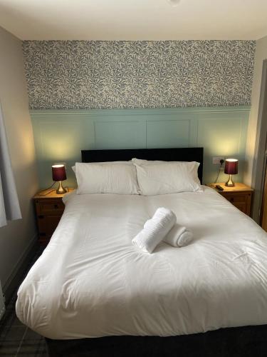 a white bed with two pillows on top of it at Durham City Cottages in Durham