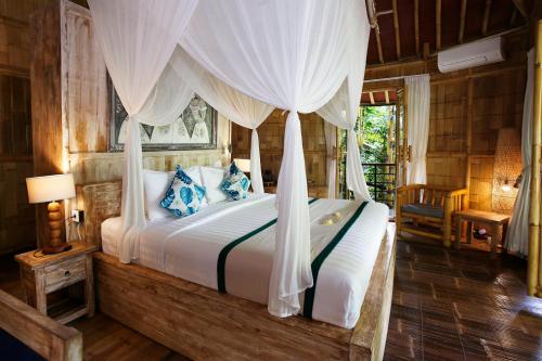 a bedroom with a bed with a canopy at Marni alas villa ubud in Tegalalang