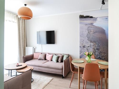 a living room with a couch and a table at MomUla's Apartment Pino Sobieszewo Gdańsk in Gdańsk