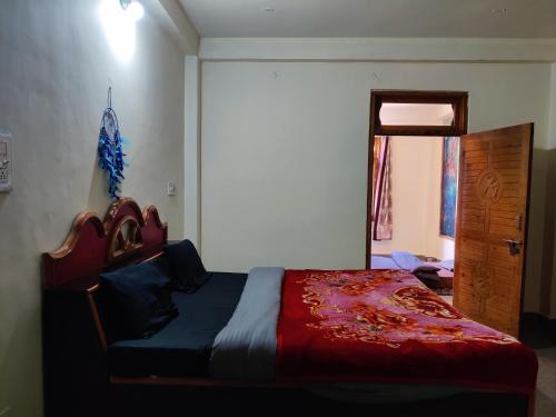 a bedroom with a bed with a red comforter at Flipsyde Retreat in Kasol