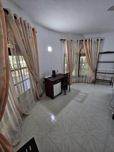 a living room with a desk and curtains at Latheena Resort in Weligama