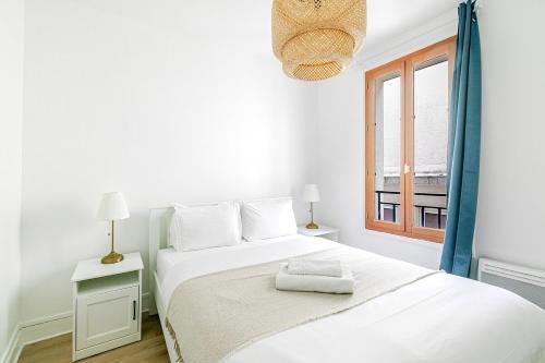 une chambre blanche avec un lit et une fenêtre dans l'établissement Nid douillet pour deux dans le Paris des artistes, à Paris
