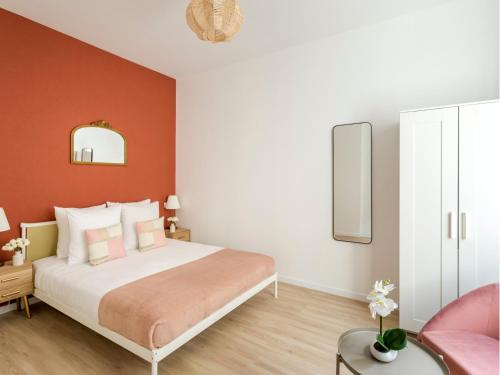 une chambre avec un grand lit aux murs orange dans l'établissement Merveil - Family Suite - Opera - Turin, à Paris