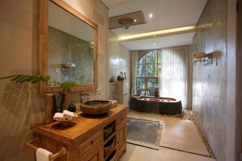 a bathroom with a wooden sink and a tub at Marni alas villa ubud in Tegalalang