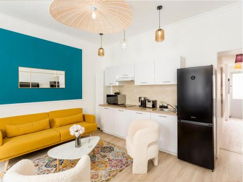 un salon avec un canapé jaune et une cuisine dans l'établissement Merveil - Family Suite - Opera - Turin, à Paris