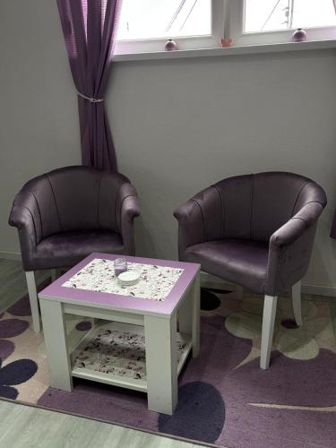 two chairs and a coffee table in a room at Apartman LILLY in Paraćin