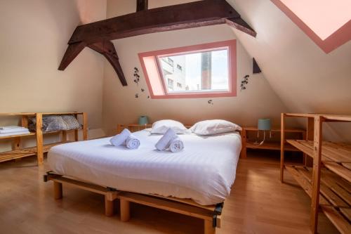 une chambre avec un lit avec des draps blancs et une fenêtre dans l'établissement Charming Duplex in Lille city center: 4 people, à Lille