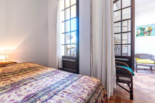 une chambre avec un lit et deux grandes fenêtres dans l'établissement Filetta - Charmant studio climatisé, à Lumio