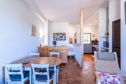 une cuisine et une salle à manger avec une table et des chaises en bois dans l'établissement Filetta - Charmant studio climatisé, à Lumio