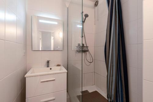 une salle de bain avec un lavabo et une douche dans l'établissement Filetta - Charmant studio climatisé, à Lumio