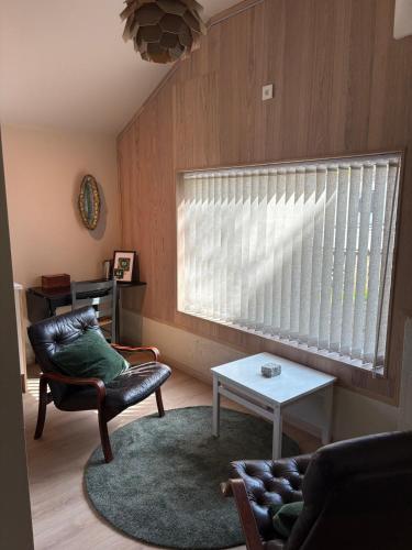 a living room with a window and a chair and a table at Tiny house in Arendal in Arendal