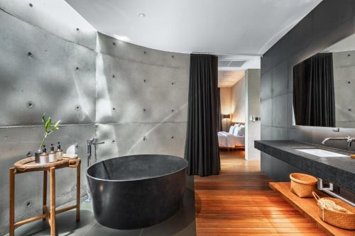 a bathroom with a large tub and a sink at Vows Villa Beachfront in Ban Bang Po