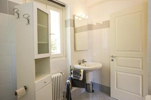 un bagno bianco con lavandino e specchio di Antiche Cure di Ghiffa a Ghiffa