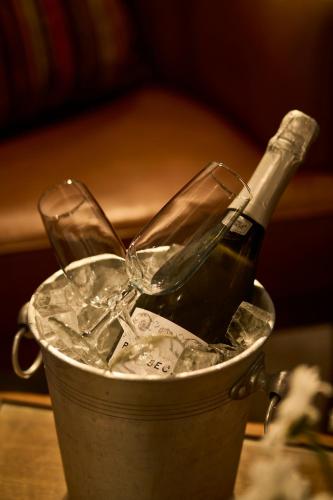 a bucket with a bottle and two glasses in ice at Stage House Bed & Breakfast in Glenfinnan