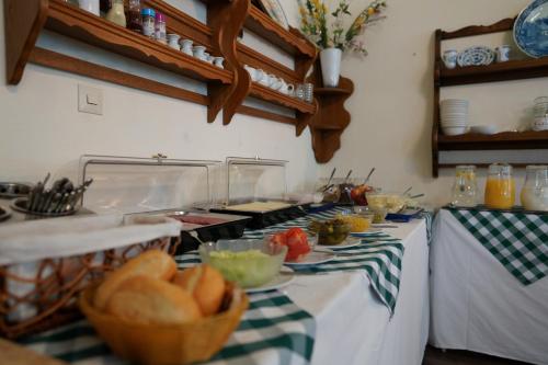 a kitchen with a counter with a table with a basket of bread at Hotel Xantener Eck in Berlin