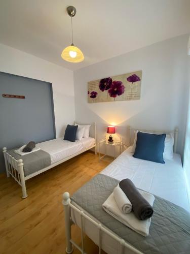 a room with two beds and a couch in it at STAY Peyia Sunset Pearl in Peyia