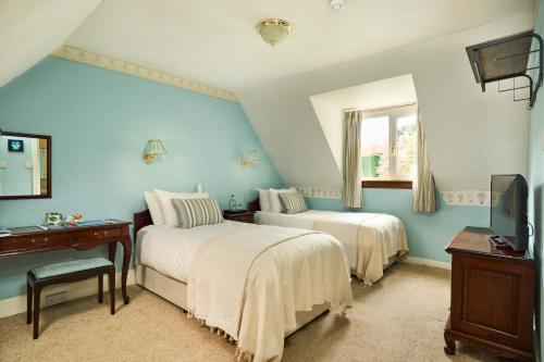 two beds in a room with blue walls at Stage House Bed & Breakfast in Glenfinnan