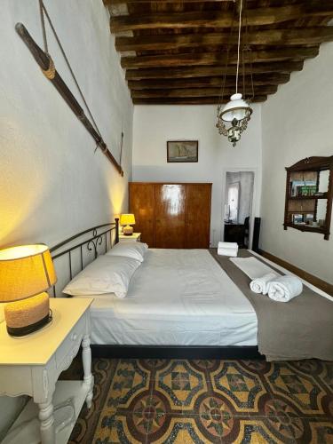 a bedroom with a bed and a desk with two lamps at Lotzia House in Kástron