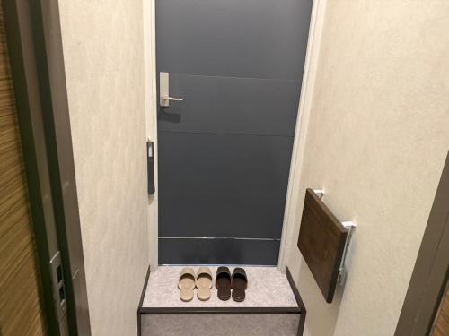 a pair of shoes sitting on a step in front of a door at ホテルクレスパアルバ in Shizuoka