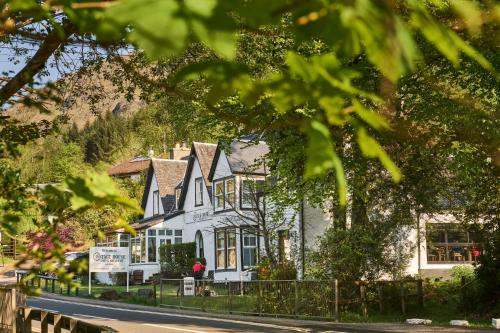 a white house with a fence in front of it at Stage House Bed & Breakfast in Glenfinnan